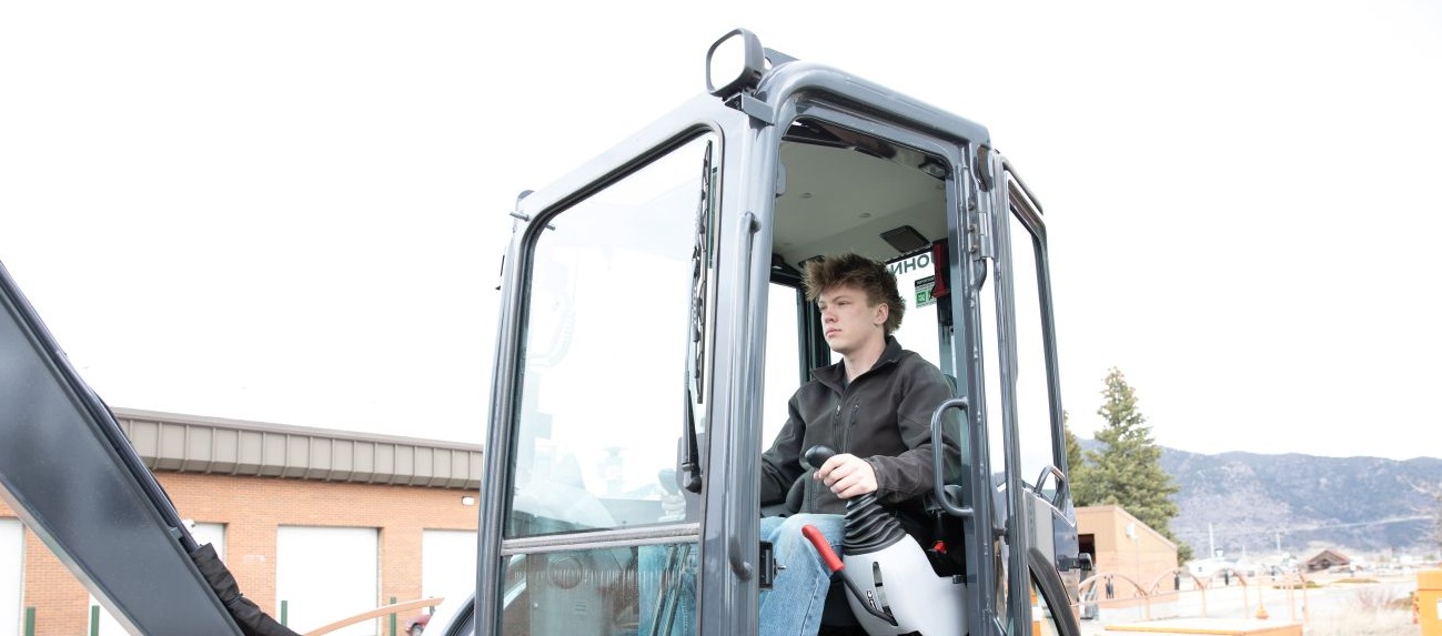 A boy driving/lifting the crane
