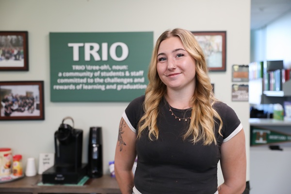 !Lily Gordon in front of the TRIO sign. 
