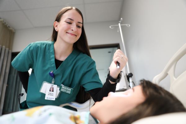 !Caitlin Olson in the nursing simulation lab with a dummy