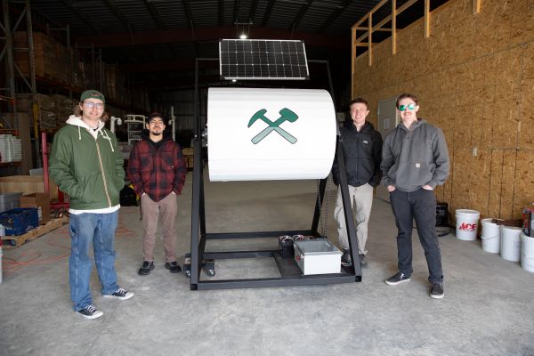 Students stand with their solar-powered composter.