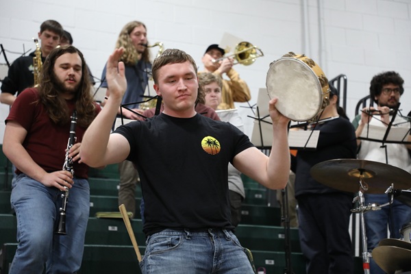 Band students perform, with someone hitting a tambourine in front